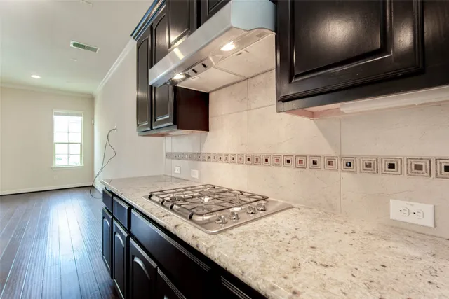 a kitchen with a stove and a wooden floor