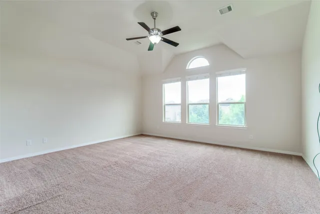 an empty room with a window and a ceiling fan