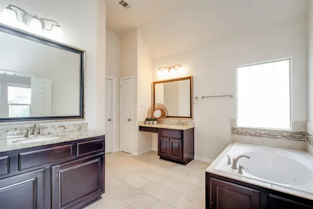 a bathroom with a tub sink and mirror