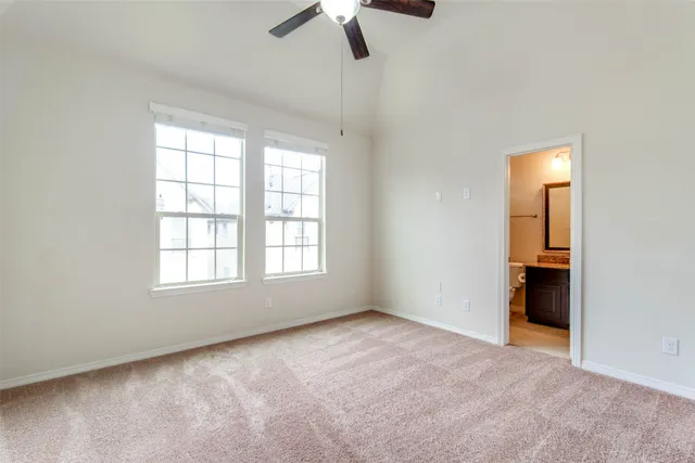 an empty room with a ceiling fan and a window