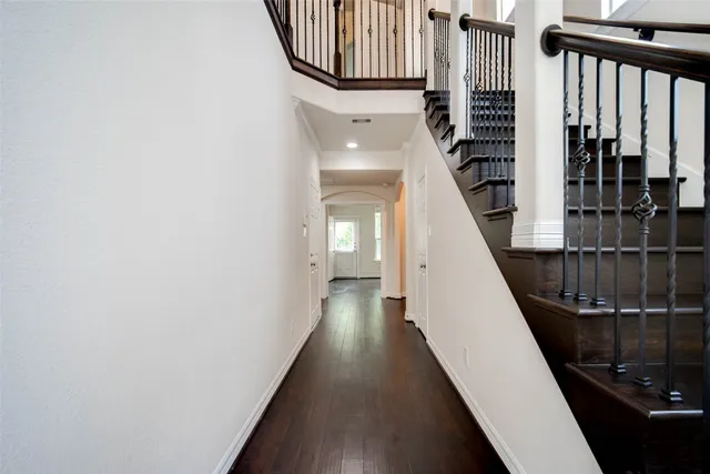 a view of a hallway with wooden floor and staircase