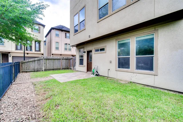 a view of a backyard with a tub and wooden fence
