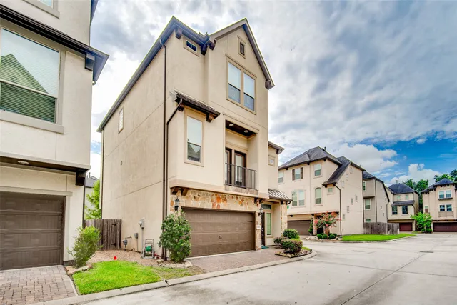 a view of a white building among the street with houses