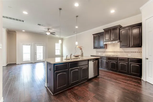 a kitchen with stainless steel appliances granite countertop wooden cabinets and sink