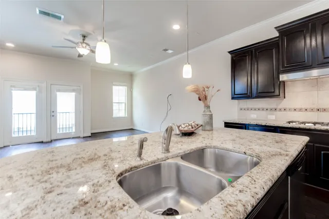 a kitchen with granite countertop a sink a counter top space appliances and cabinets