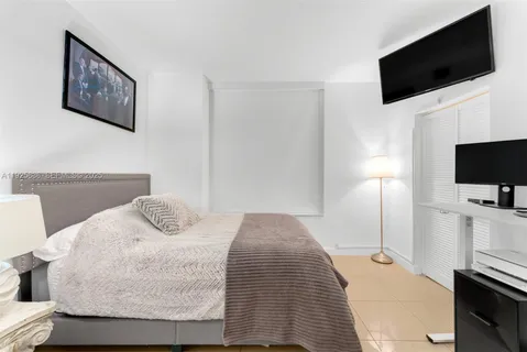 a bedroom with a bed and a flat screen tv