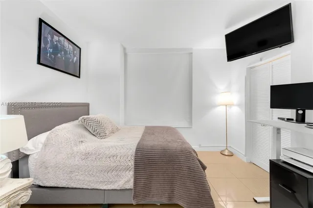 a bedroom with a bed and a flat screen tv