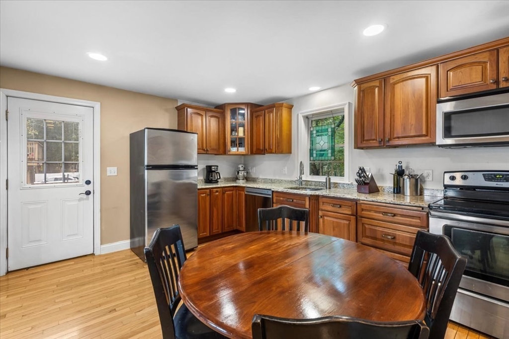 20 Cooks Lane Bellingham, MA 02019 - Photo 9 of 21 a kitchen with stainless steel appliances granite countertop a sink a stove a refrigerator cabinets and a dining table