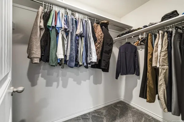 a view of walk in closet with clothes and shoes