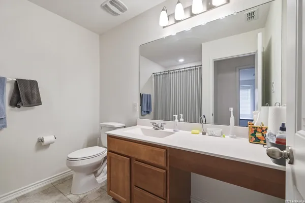 a bathroom with a sink a toilet and mirror