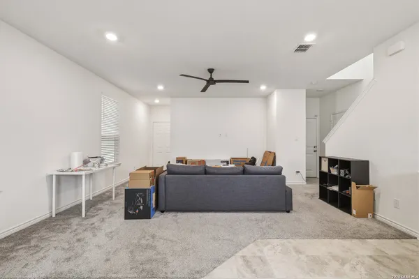a living room with furniture and a ceiling fan