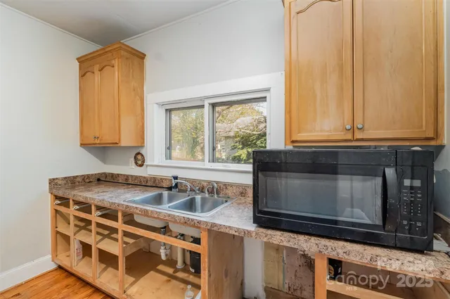a kitchen with granite countertop a sink stove and microwave