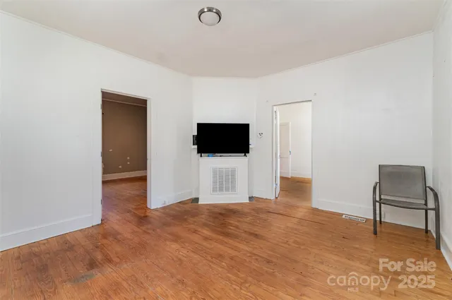 a view of a livingroom with wooden floor and a flat screen tv