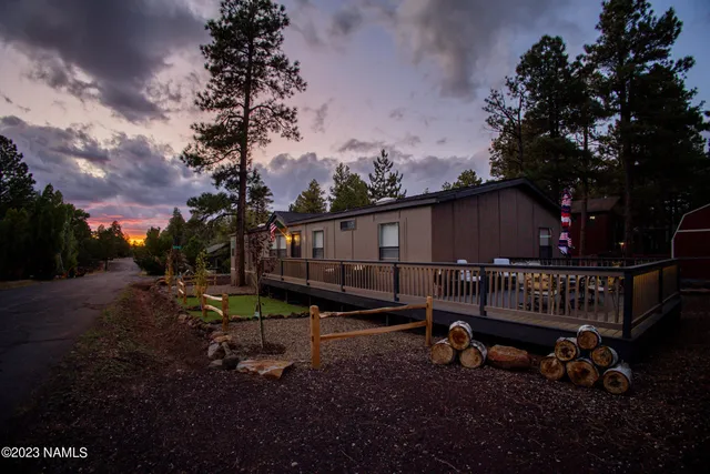 a kitchen view with stainless steel appliances a sink dishwasher a refrigerator a stove and white cabinets with wooden floor