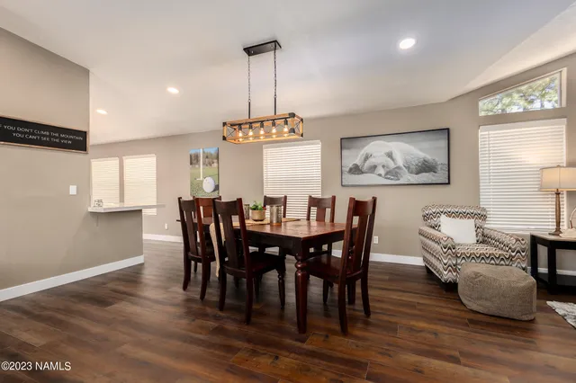 a kitchen with stainless steel appliances a refrigerator a stove and white cabinets with wooden floor