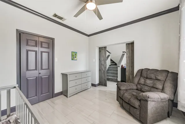 a living room with furniture and a walk in closet with wooden floor