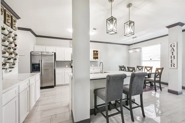 a kitchen with stainless steel appliances a dining table chairs and chandelier