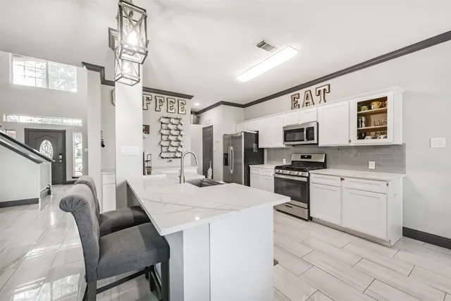 a kitchen with stainless steel appliances kitchen island granite countertop a sink and cabinets