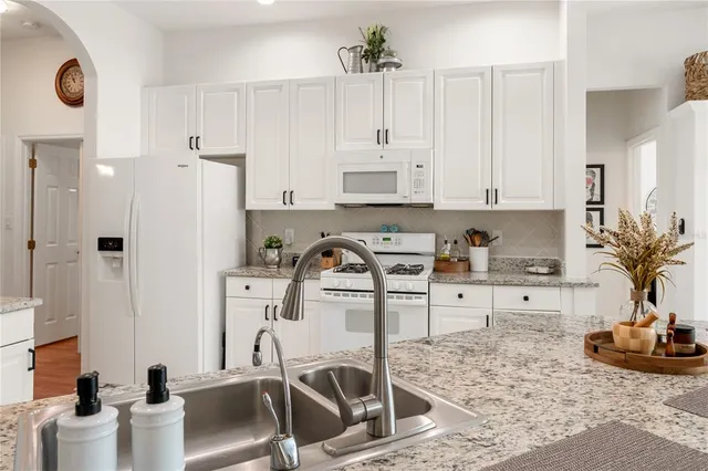 a kitchen with stainless steel appliances kitchen island sink refrigerator and cabinets