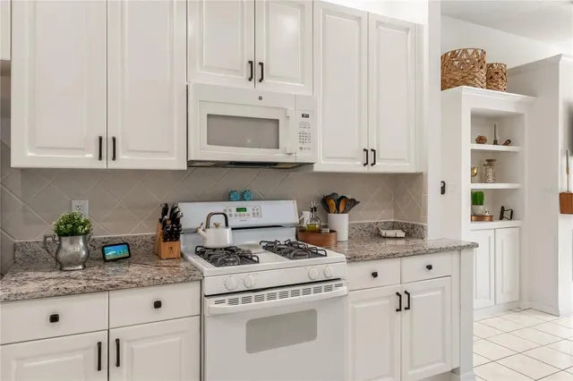 a kitchen with white cabinets and white appliances