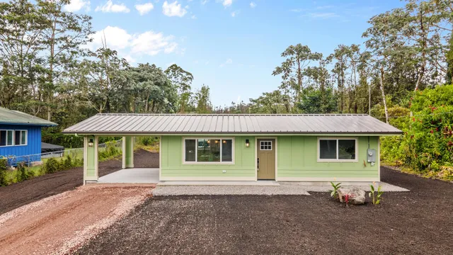 a front view of a house with a garden and trees