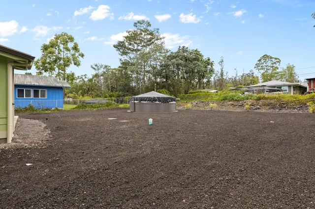 a view of a house with backyard and a tree