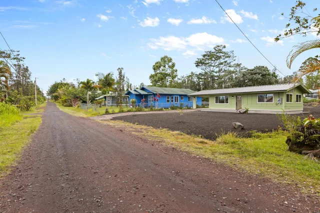 a view of a house with a yard and sitting area