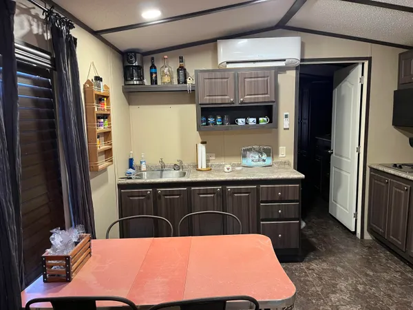 a room with stainless steel appliances kitchen island granite countertop a refrigerator