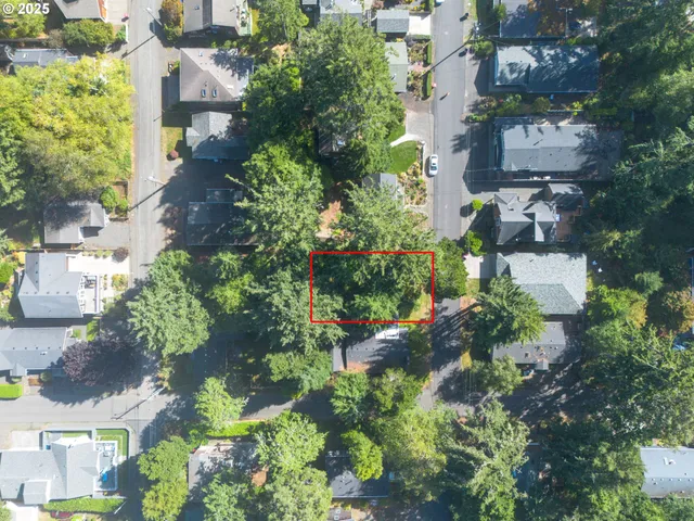 an aerial view of a residential apartment building with plants and large trees