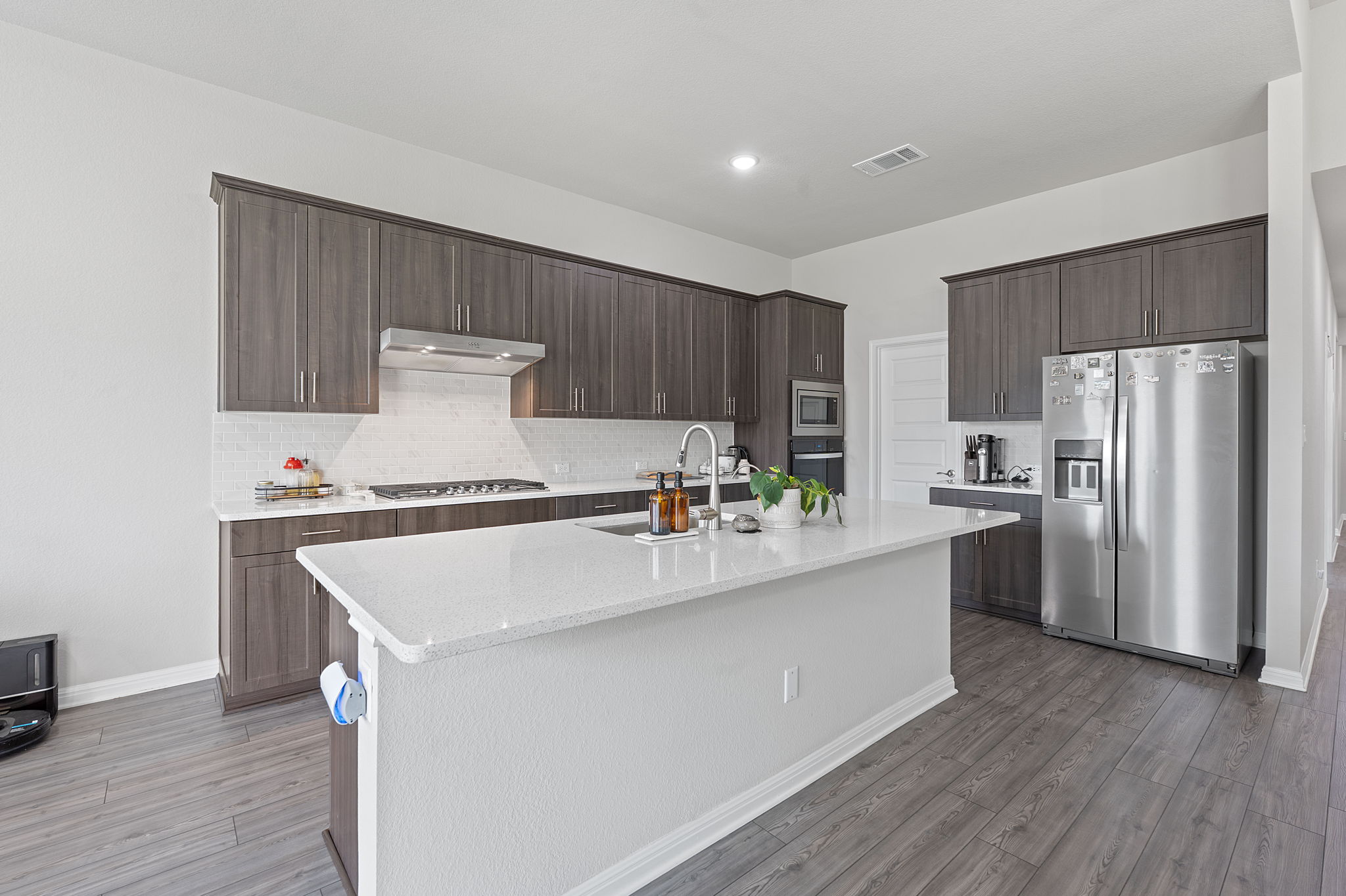 571 Sue Peaks Loop Dripping Springs, TX 78620 - Photo 7 of 29 a kitchen with a sink a refrigerator and a stove
