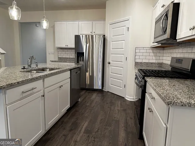 a kitchen with a sink stove and refrigerator