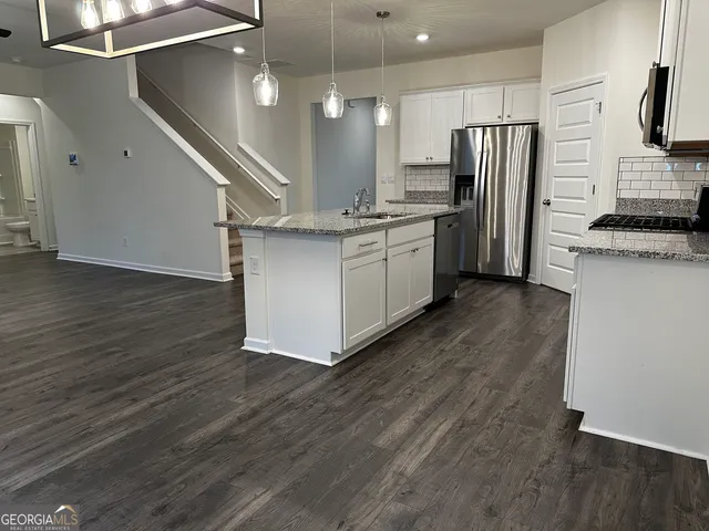 a kitchen with stainless steel appliances a refrigerator and a stove top oven