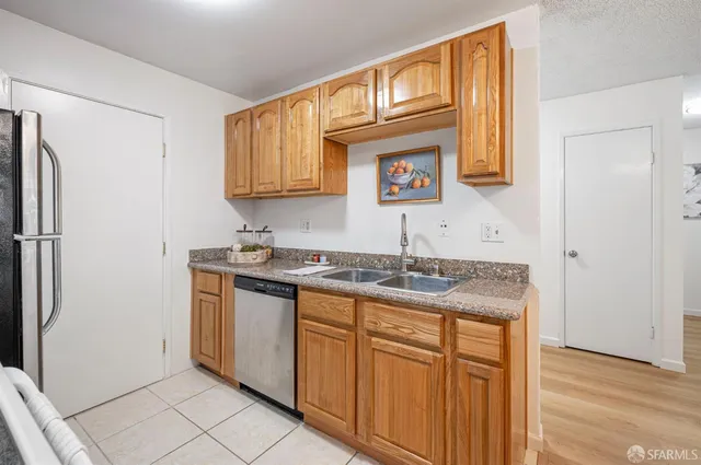 a kitchen with stainless steel appliances granite countertop a sink and a refrigerator