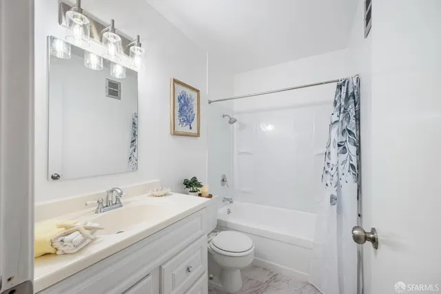 a bathroom with a granite countertop sink a toilet and a mirror