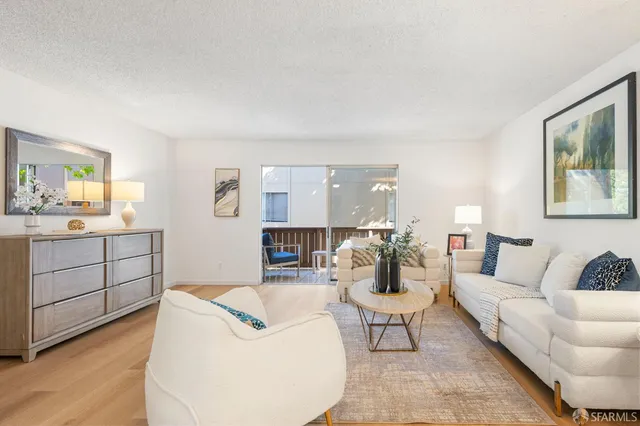 a living room with furniture a rug and white walls