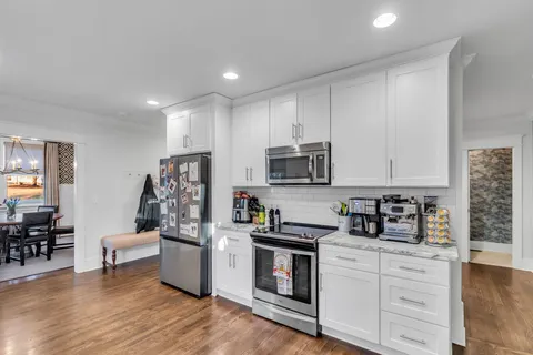 a kitchen with white cabinets and stainless steel appliances