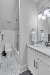 a bathroom with a sink a toilet and a mirror