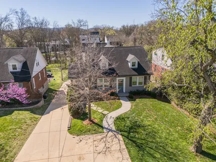 an aerial view of residential houses with outdoor space and trees