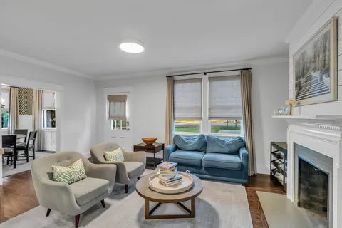 a living room with furniture a fireplace and a large window