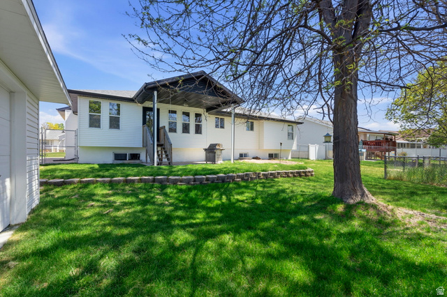 2460 Allison Way Syracuse, UT 84075 - Photo 23 of 24 Expansive green lawn with a mature tree