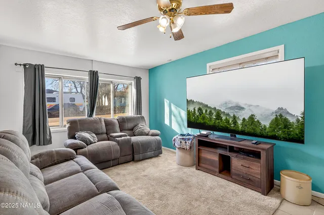a living room with furniture a flat screen tv and a floor to ceiling window