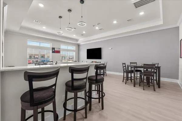 a kitchen with a dining table chairs cabinets and stainless steel appliances