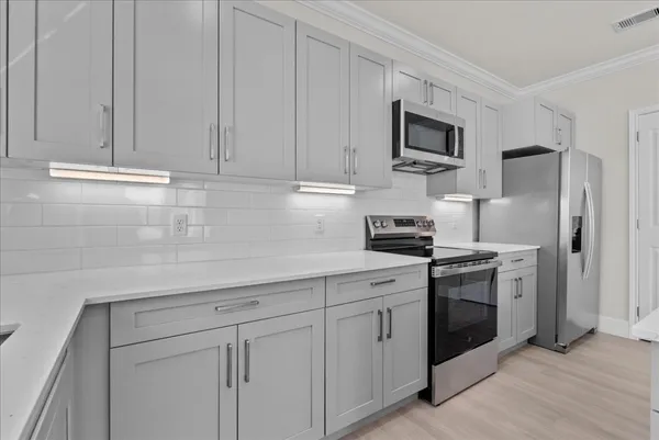 a kitchen with white cabinets and stainless steel appliances