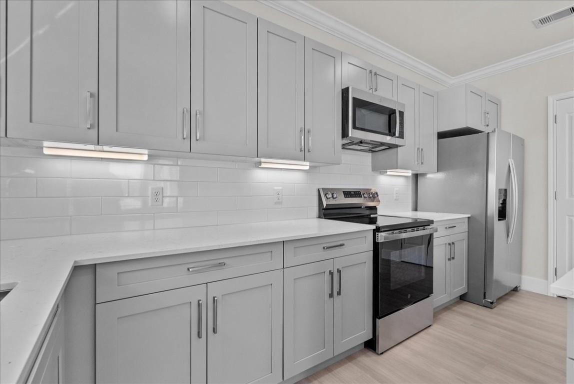 540 Hobbs Road, Unit D1 League City, TX 77573 - Photo 5 of 44 a kitchen with white cabinets and stainless steel appliances
