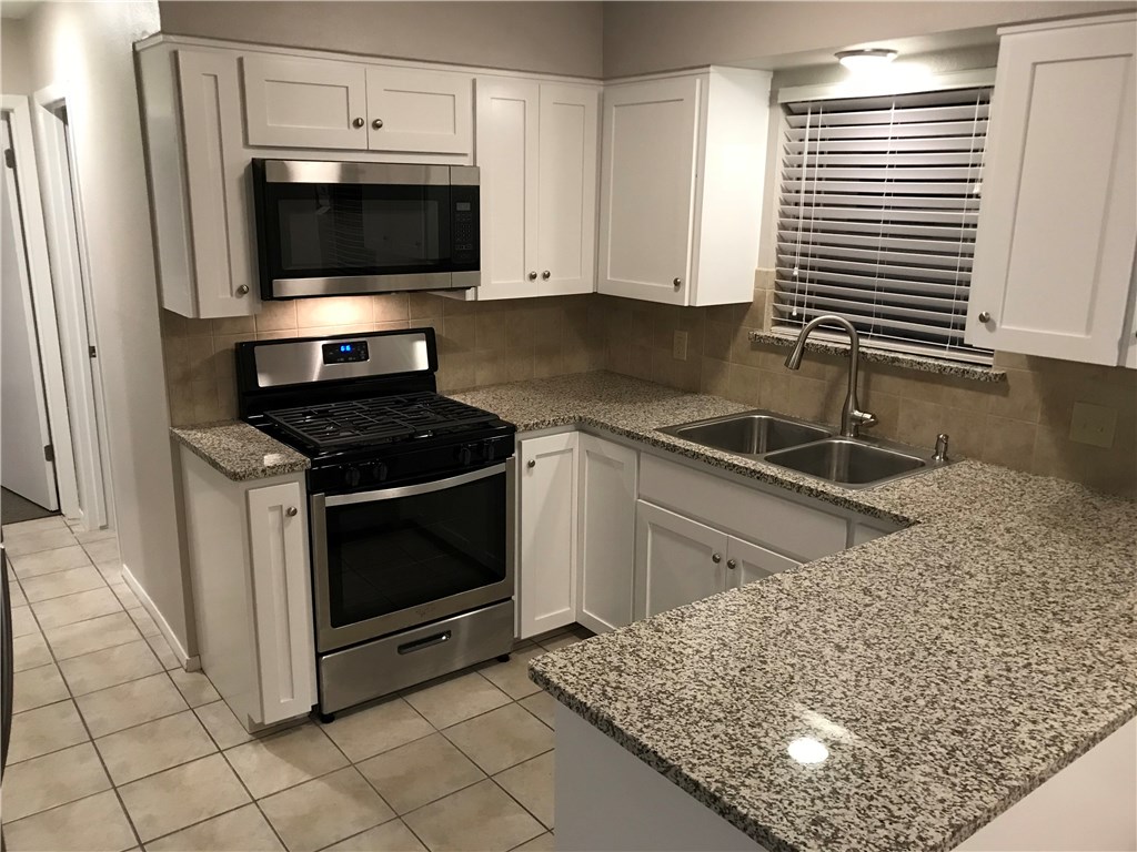 1810 Berkeley Avenue, Unit B Austin, TX 78745 - Photo 1 of 9 Features Shaker cabinet doors, SS appliances, granite countertops and space saver microwave.