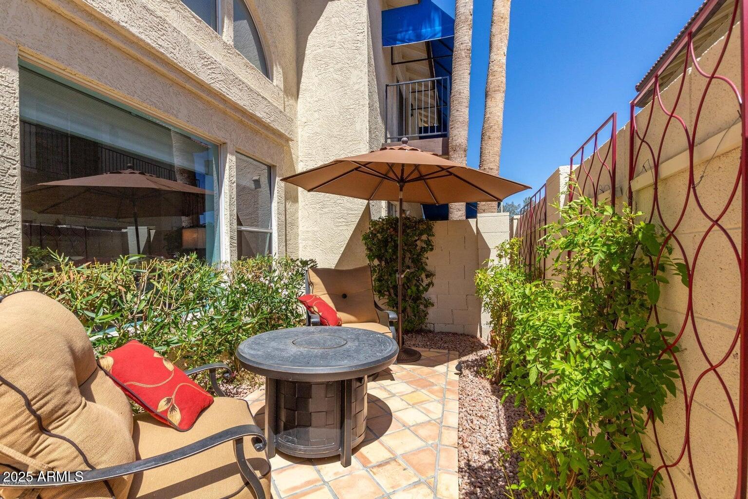 8841 South 51st Street, Unit 1 Phoenix, AZ 85044 - Photo 17 of 23 a view of a patio with table and chairs under an umbrella