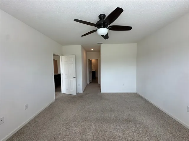 an empty room with a window and a ceiling fan