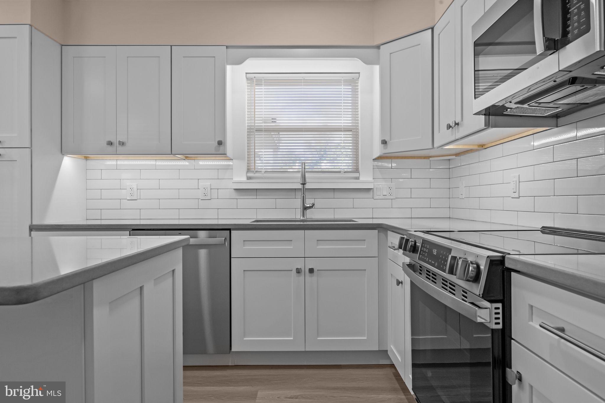 1838 Sheri Road Bensalem, PA 19020 - Photo 13 of 43 a kitchen with granite countertop a sink stainless steel appliances white cabinets and a window