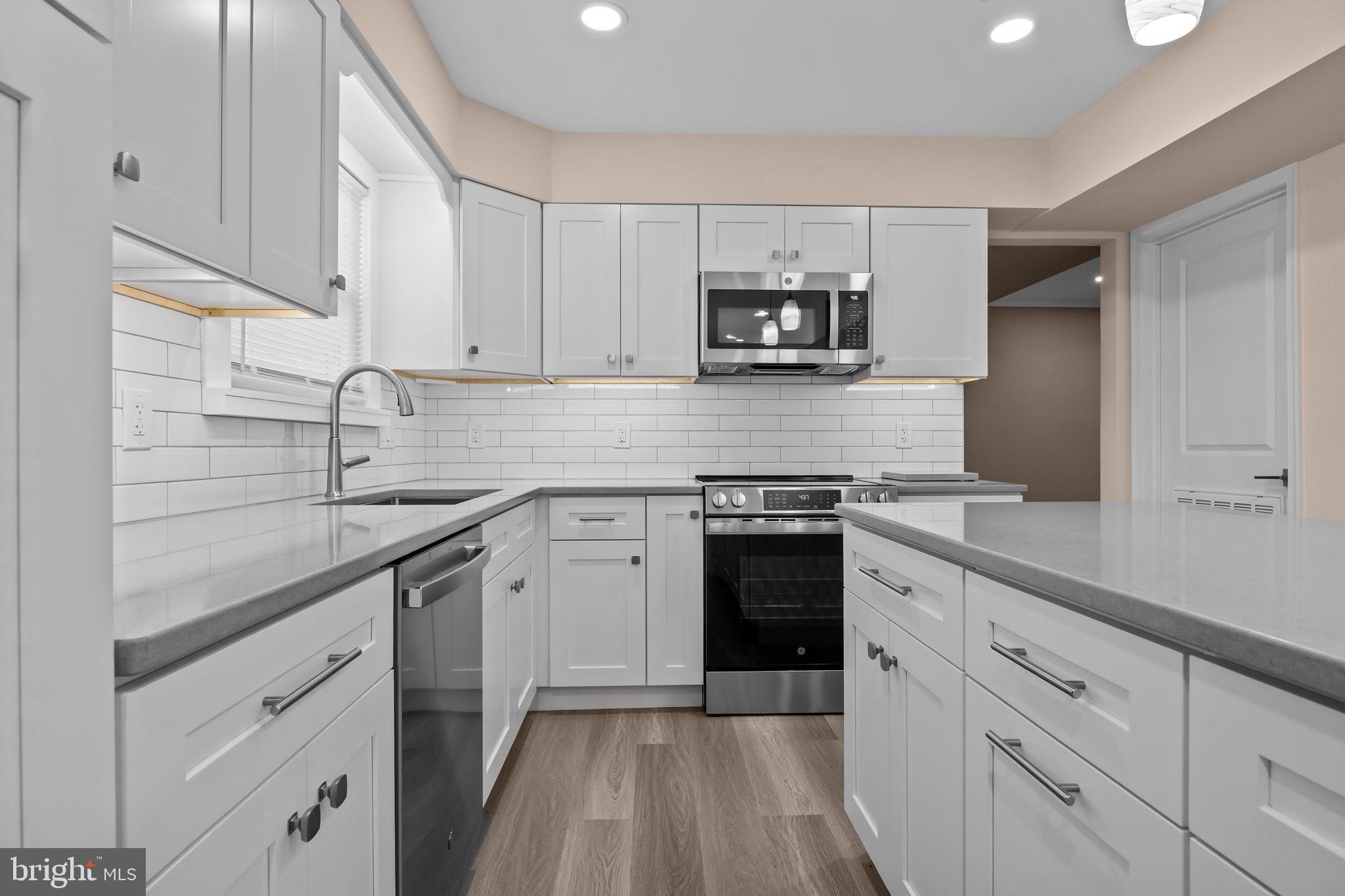 1838 Sheri Road Bensalem, PA 19020 - Photo 14 of 43 a kitchen with stainless steel appliances granite countertop white cabinets a sink a stove a microwave and cabinetry