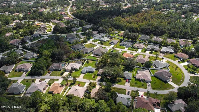 an aerial view of residential houses with outdoor space and trees